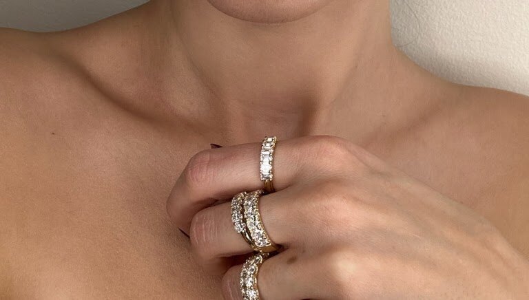 Stacked rings worn on hand in soft lifestyle photo
