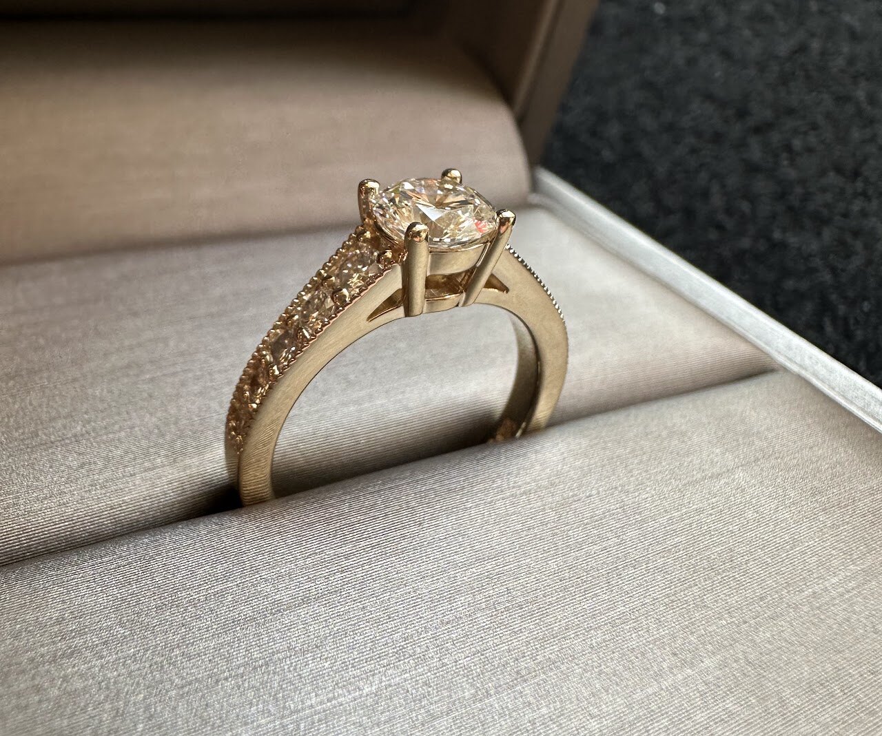 Yellow gold engagement ring with center stone in box