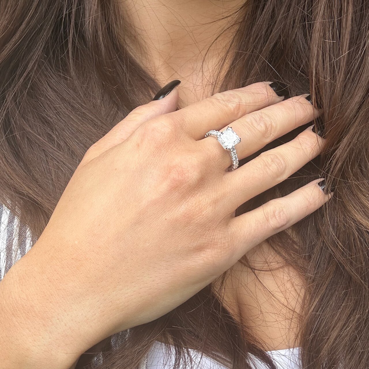 Engagement ring worn on hand with soft hair and skin detail
